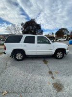2003 Chevrolet Tahoe 4x4 in white, fully loaded with leather seats and a tow package, parked on gravel.