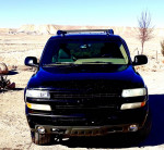 2005 Chevrolet Tahoe LS 4WD in black, parked in a desert landscape with a clear sky.