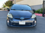 Front view of a 2011 Toyota Prius with 145,000 miles, showing minor cosmetic damage and a mismatched rim.
