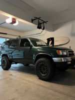 1999 Toyota 4Runner SR5 in Imperial Jade Green, featuring manual transmission and aftermarket upgrades, parked in a garage.
