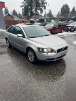2006 Volvo S40 2.4i sedan in silver, showcasing its front exterior in rainy weather.