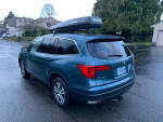 2017 Honda Pilot EX-L AWD with Yakima roof rack, leather interior, and 54,000 miles parked on a wet driveway.