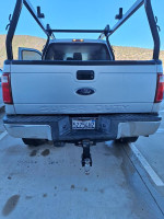 Rear view of a 2016 Ford F250 Super Duty truck with a custom lumber rack and tow package.