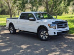 2014 Ford F-150 FX4 4WD parked on the road, showcasing its sleek white exterior and stylish design.