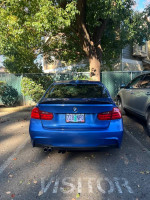 Rear view of a 2013 BMW 328i Xdrive in blue parked, showcasing excellent condition and features.