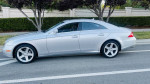 2007 Mercedes-Benz CLS550 silver sedan with low mileage parked on the street, showcasing its sleek design and premium features.