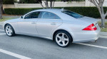 2007 Mercedes-Benz CLS550 in silver with low mileage and elegant design, parked on a street.