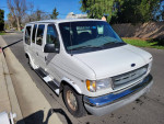 2000 Ford E-150 Triton Camper van with clean title, parked on the street, showing its spacious design.